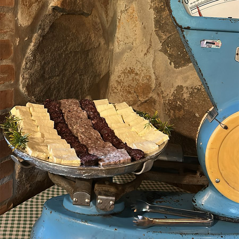 Fatias de queijo fresco artesanal e linguiça colonial artesanal da região de Caraá, servidas juntas.