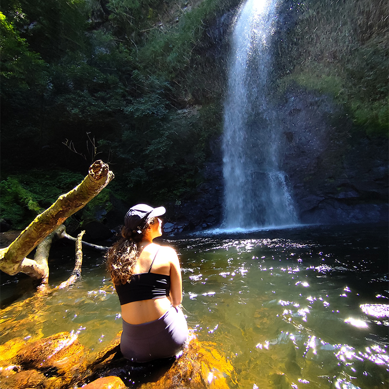 Visitante contemplando a queda d’água da Cascata da Nascente do Rio dos Sinos durante a trilha em Caraá.
